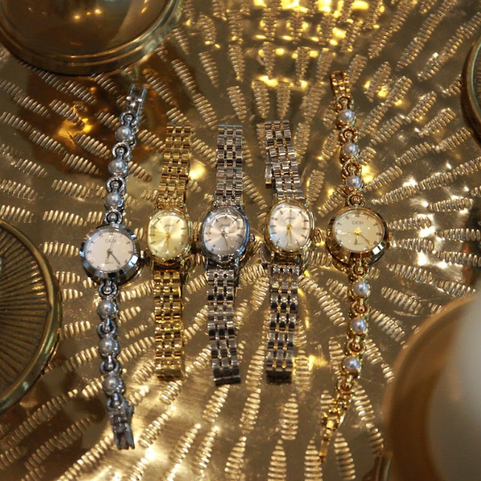 Collection of watches on a reflective gold surface