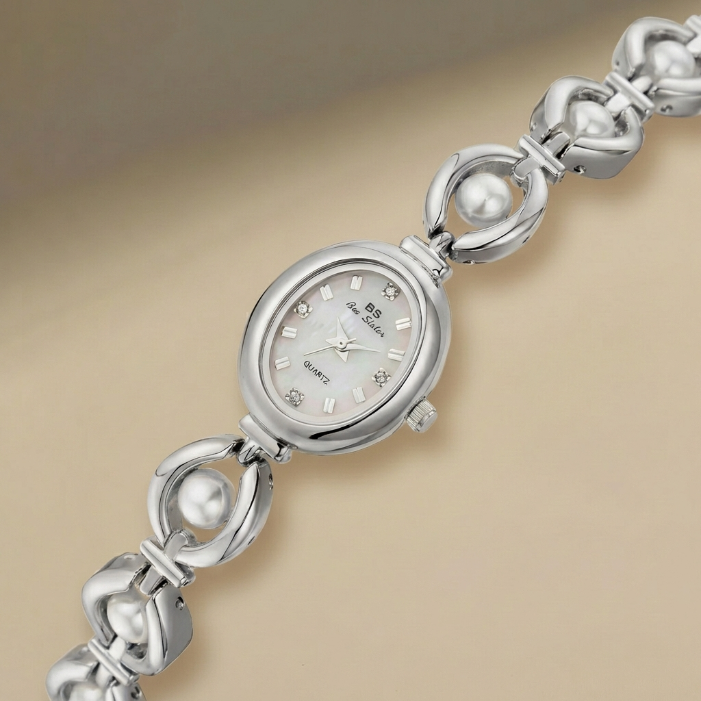 Silver bracelet watch with pearl accents on a beige background