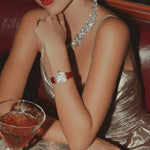 Woman in a glamorous setting with a drink and jewelry