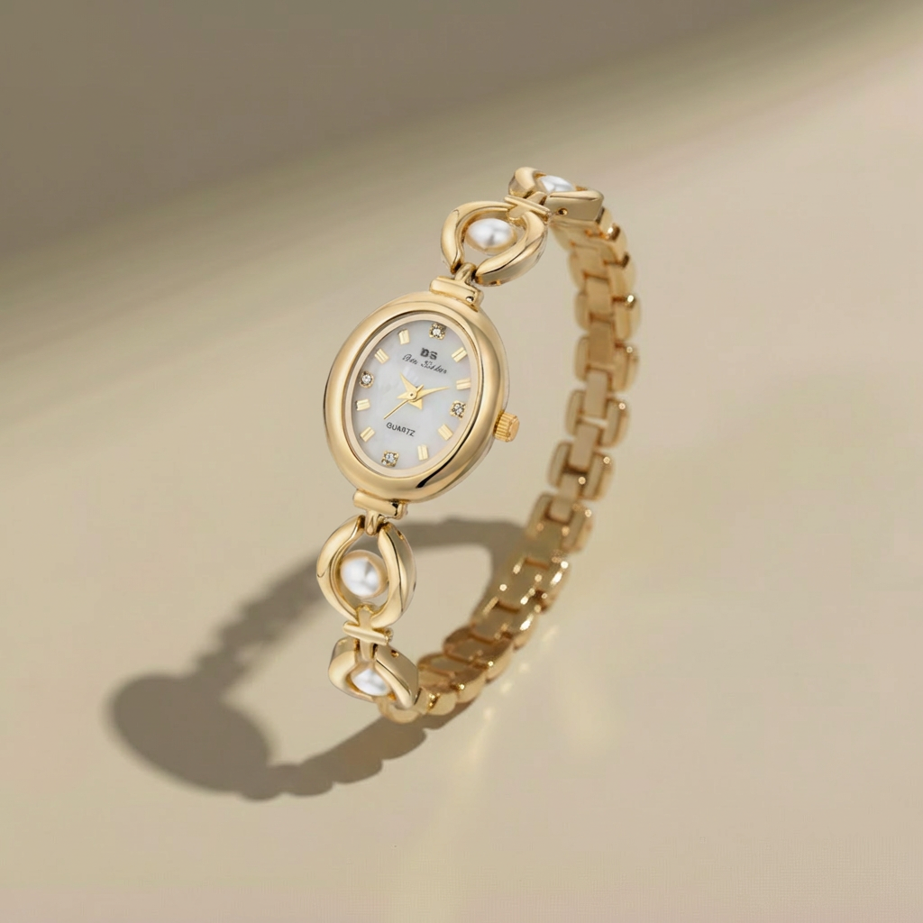 Gold wristwatch with pearl-like accents on a beige background